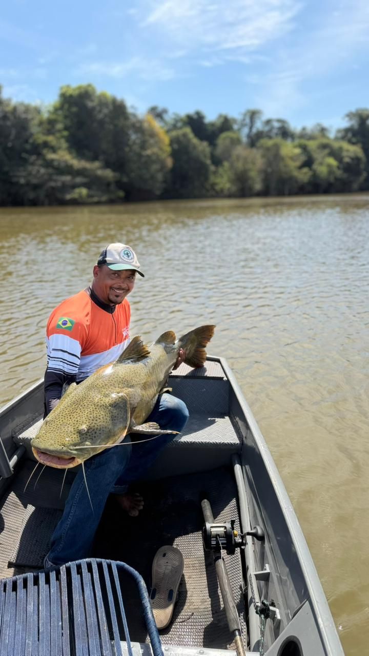 Angler at the bow of a boat with a large jaú